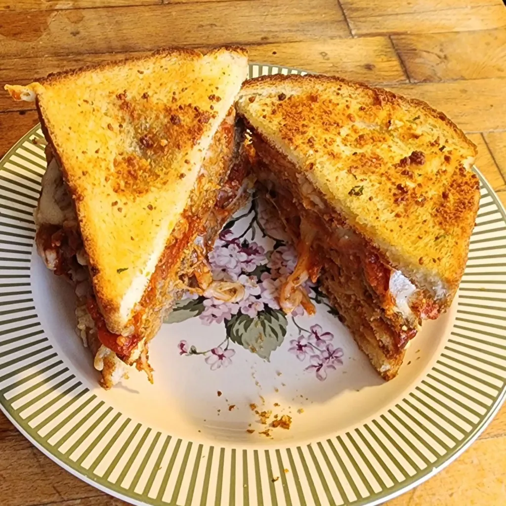 The Meatball Club:  A double-decker meatball sandwich on toasted white bread, teeming with tasty sauce & melted Gruyere and Swiss cheese.  (Cut open diagonally, from the top.)

